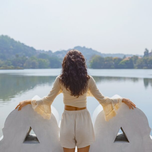 Traveler enjoying the view over Kandy Lake with surrounding hills, capturing a serene moment in kandy travel.